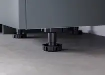 Højdejusterbar REDOCOL-fod til stabil justering af et møbelkorpus.