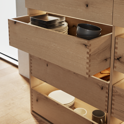 Echt houten keukenkast met geopende houten lades met vingerlas op maat