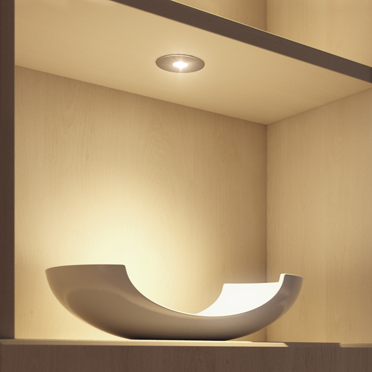 Moderne LED spotarmatuur ingebouwd in het plafond, verlicht gericht de kastinhoud – ideaal voor accentverlichting.