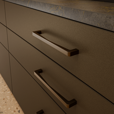 Bronzefarbener Designgriff Annemarie an einer modernen Küchenfront mit Schubladen und Stein-Arbeitsplatte.