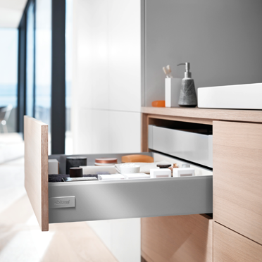 Geöffneter Blum Tandembox antaro K Schubkasten in Weißaluminium in einem modernen Waschtischunterschrank