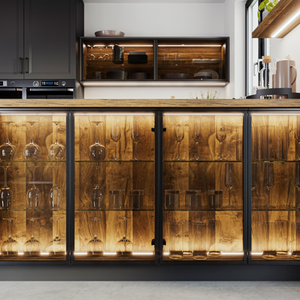 Kuechenzeile mit beleuchteten schwarzen Glasrahmenfronten.