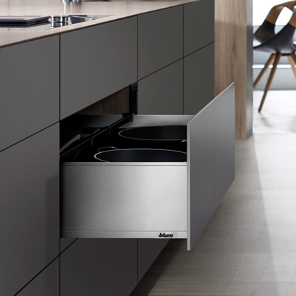 Geöffneter Blum Legrabox Schubkasten in einer modernen Kücheninsel mit dunklen Fronten