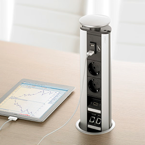 Möbelsteckdose in einem Schreibtisch mit ladendem Tablet